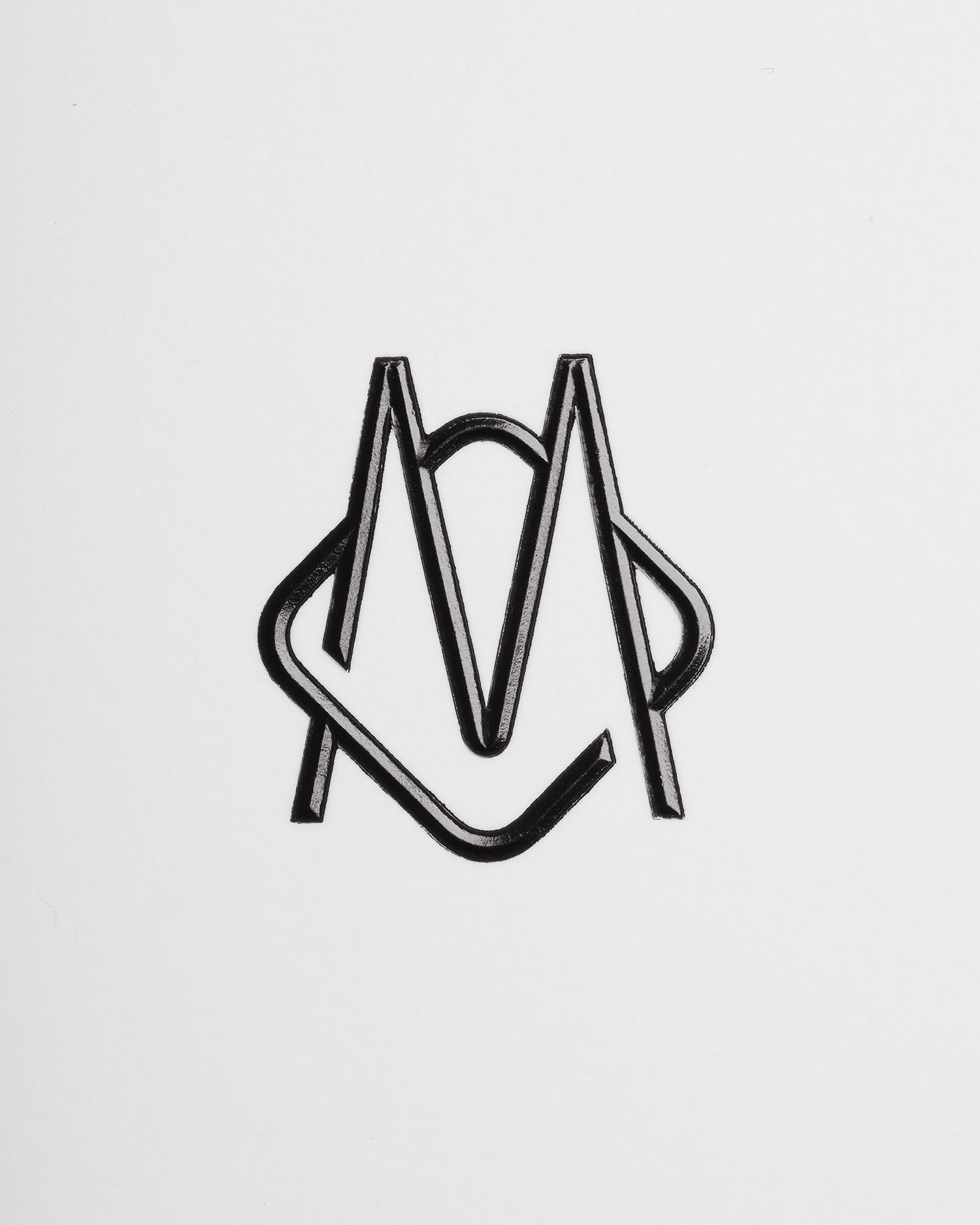 This design features a clean, geometric monogram formed by two stylized, intertwined uppercase 'M' shapes. The visual language relies on thick, precise line work and strong negative space to create a balanced and sophisticated mark. The overall feel is modern, structured, and highly refined.
