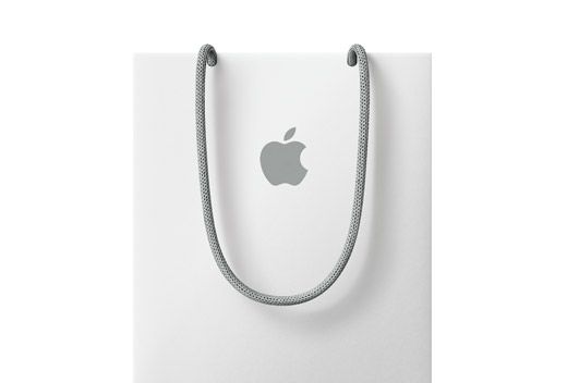 This is a clean, minimalist product shot featuring an Apple logo pendant suspended from a fine silver cord. The visual language emphasizes subtlety, quality, and brand recognition through simple lines and monochrome tones.