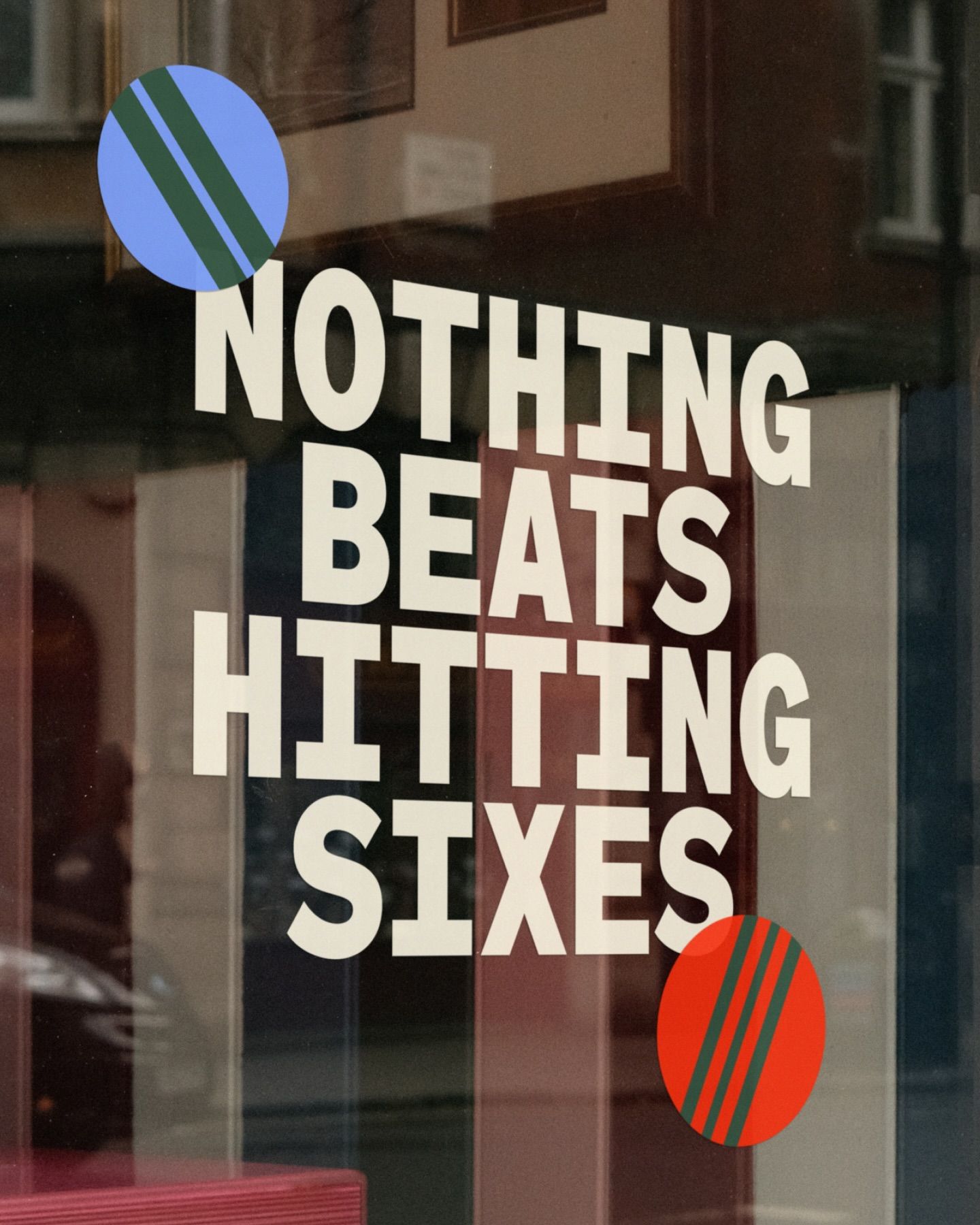 This is a minimalist, typographic design featuring bold, capitalized text overlaid on a glass surface. The composition relies heavily on negative space and the stark contrast between white text and the dark background, creating a clean and assertive visual statement.