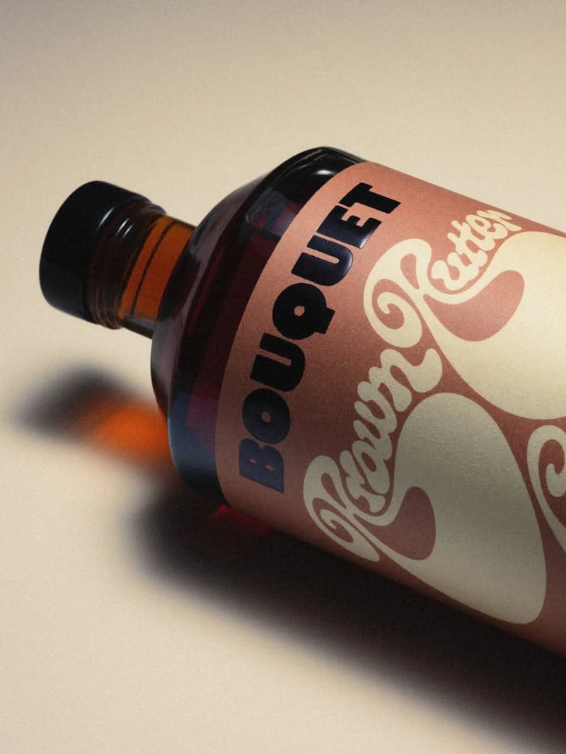 This is a product photograph featuring a dark glass bottle with a label, suggesting a cosmetic or artisanal product. The design employs a muted, earthy color palette with elegant, flowing typography that conveys a sense of natural luxury and sophistication.