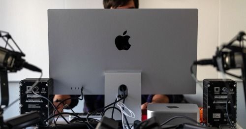 This image captures a professional workspace centered around high-end computing equipment, emphasizing a clean, modern aesthetic typical of media production or design studios. The visual language relies on minimalist hardware and functional organization, creating a focused atmosphere where technology is the primary subject.