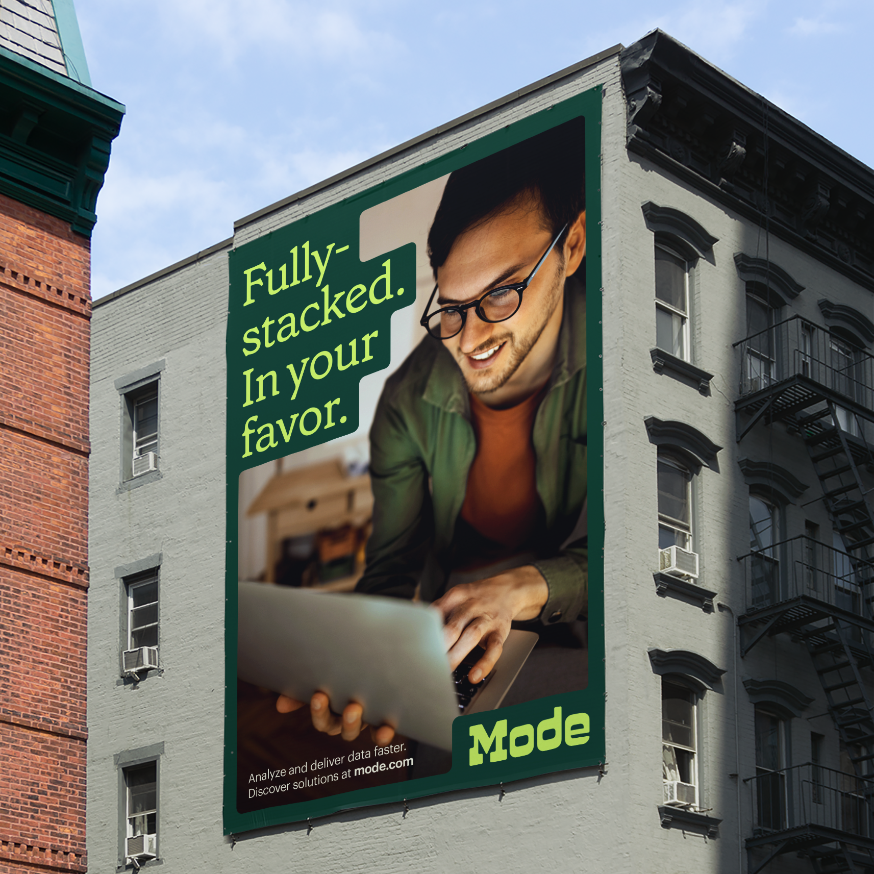 A large-scale outdoor advertisement featuring a modern, lifestyle-oriented design with a confident male figure using a laptop against a rich forest green background. The composition combines contemporary photography with bold, sans-serif typography to convey tech-forward messaging and professional empowerment.