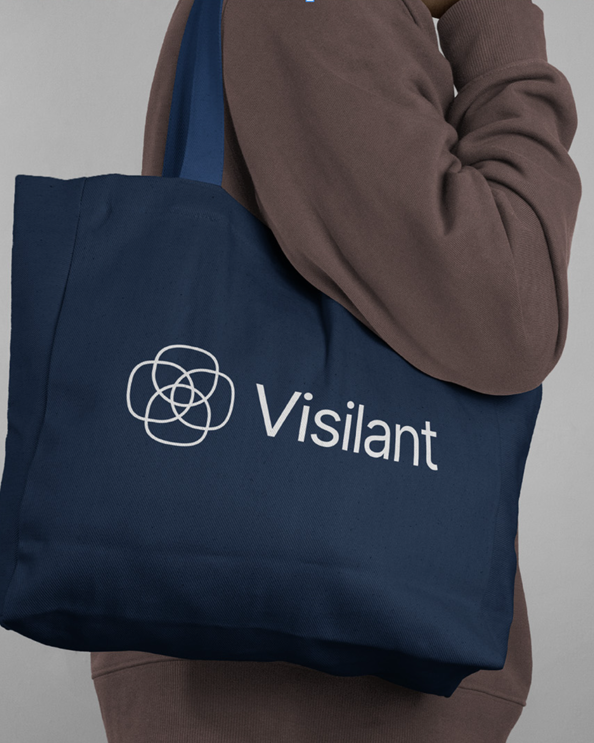 This image showcases a minimalist presentation of branded merchandise, pairing deep navy fabric with warm, earthy tones. The visual language is clean and functional, emphasizing a high-quality, casual aesthetic suitable for lifestyle or retail products.