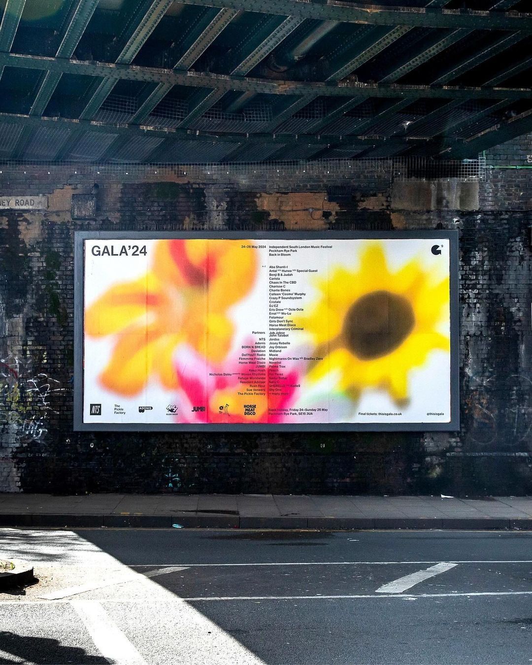 This is a promotional display, likely for an event named 'GALA'24', featuring a vibrant, large-scale photographic or graphic element dominated by warm yellows and oranges, suggesting energy and warmth. The presentation is clean and modern, utilizing high contrast against a dark background to draw immediate attention to the visual centerpiece.