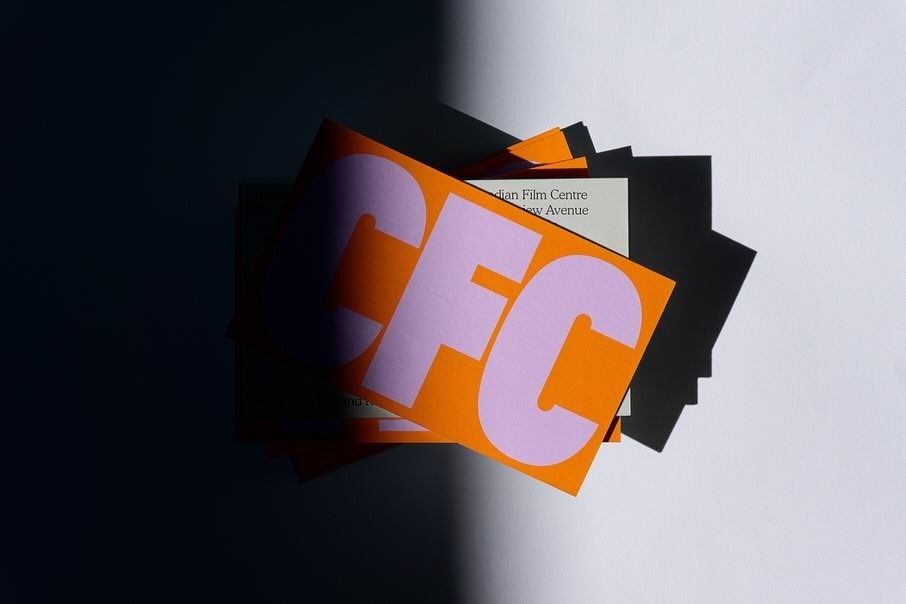 This image showcases a dynamic study in layering and high contrast, utilizing geometric paper elements to create depth. The design relies on the interplay between vibrant orange and muted pink against deep shadows, resulting in a striking and modern visual statement.