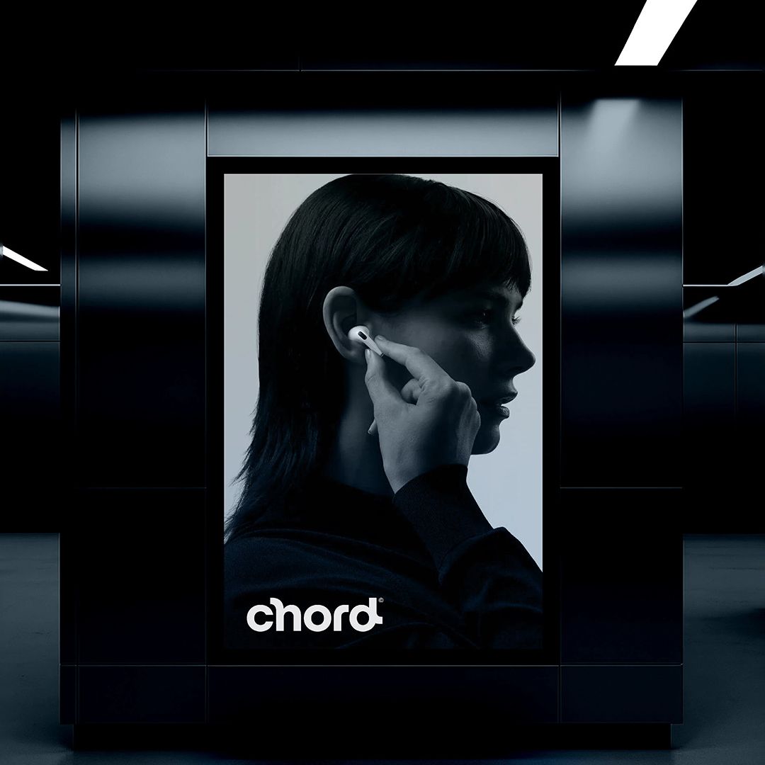 The image presents a sleek, high-contrast product shot emphasizing minimalist design and sophisticated technology. The lighting is controlled, creating deep shadows and sharp highlights that focus attention entirely on the subject's profile and the product integration.