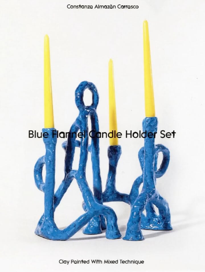 A sculptural candle holder set featuring organic, abstract blue forms with an expressive, gestural quality. The design combines contemporary art with functional home décor, showcasing handcrafted clay elements with a raw, textured finish and vibrant yellow candles inserted throughout the composition.