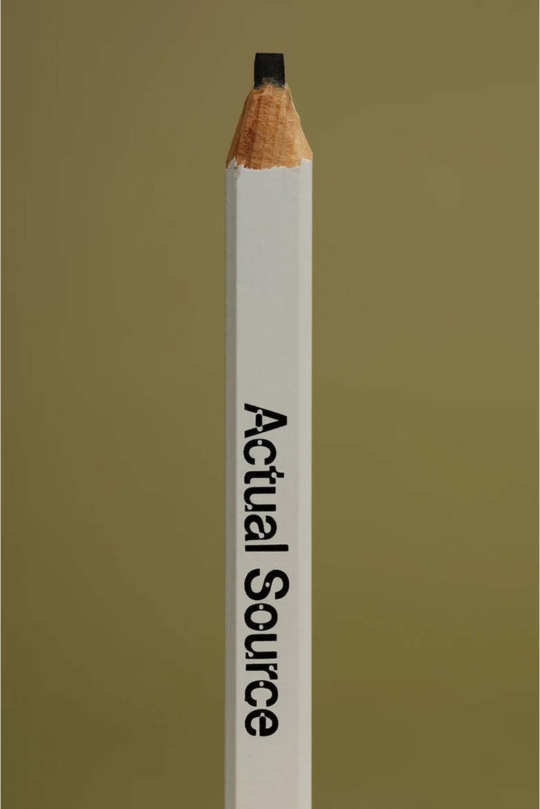 This image presents a stark, minimalist study of a drawing tool, utilizing strong vertical composition and high contrast to highlight form. The visual language is clean and editorial, focusing attention on the texture of the pencil and the precise typography used for branding.