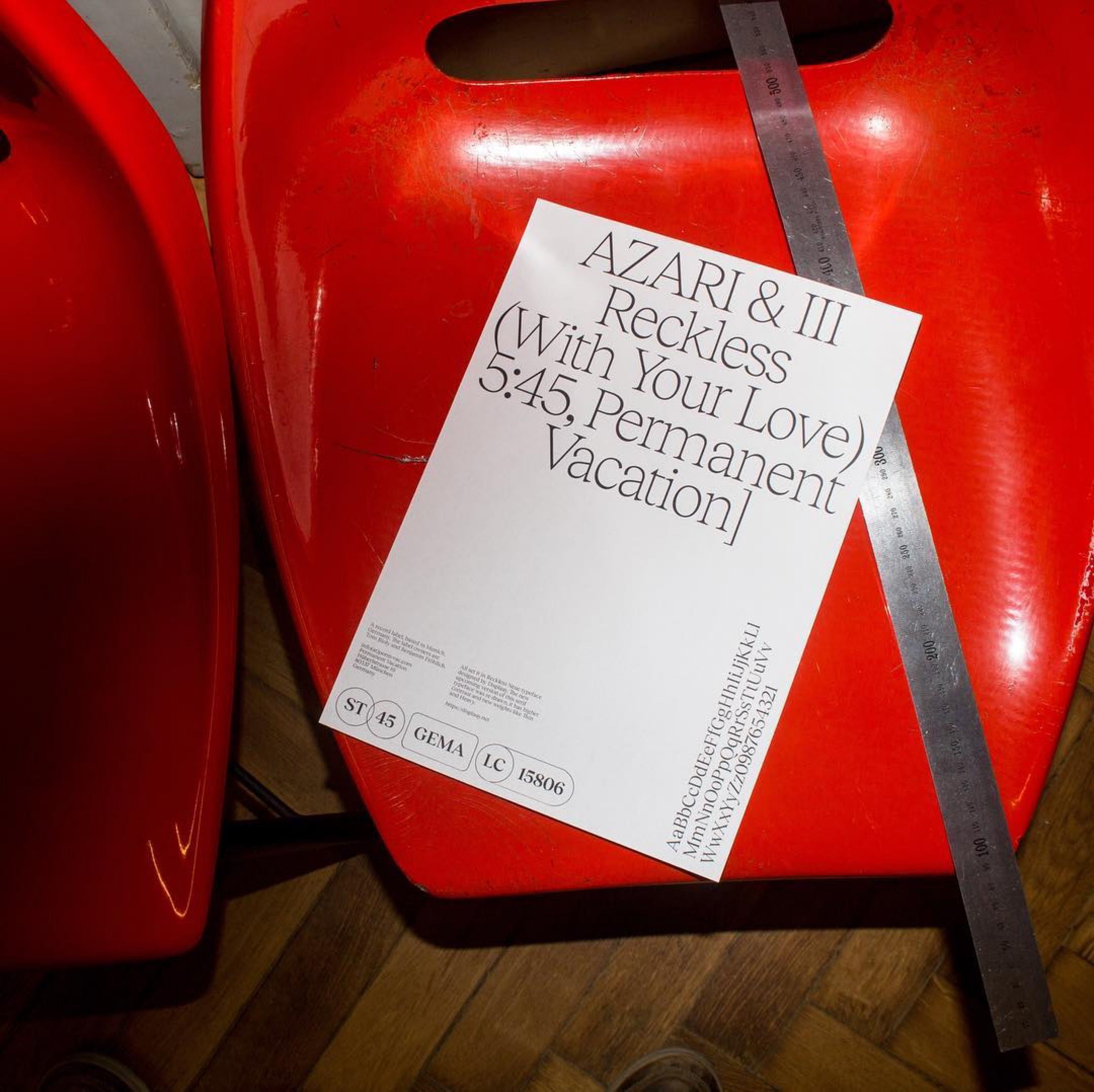 The image features a vibrant, monolithic red object serving as a bold backdrop for overlaid white typography. The design juxtaposes a raw, physical form with stylized, casual text, creating an energetic and slightly retro aesthetic.