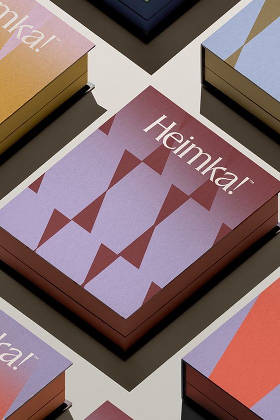 A sophisticated book cover design featuring geometric abstraction with a minimalist aesthetic. The composition uses a carefully curated color palette of muted pastels and earth tones, with a repeating triangular pattern creating visual rhythm and depth. The design demonstrates contemporary editorial sensibility with clean typography and refined material presentation.