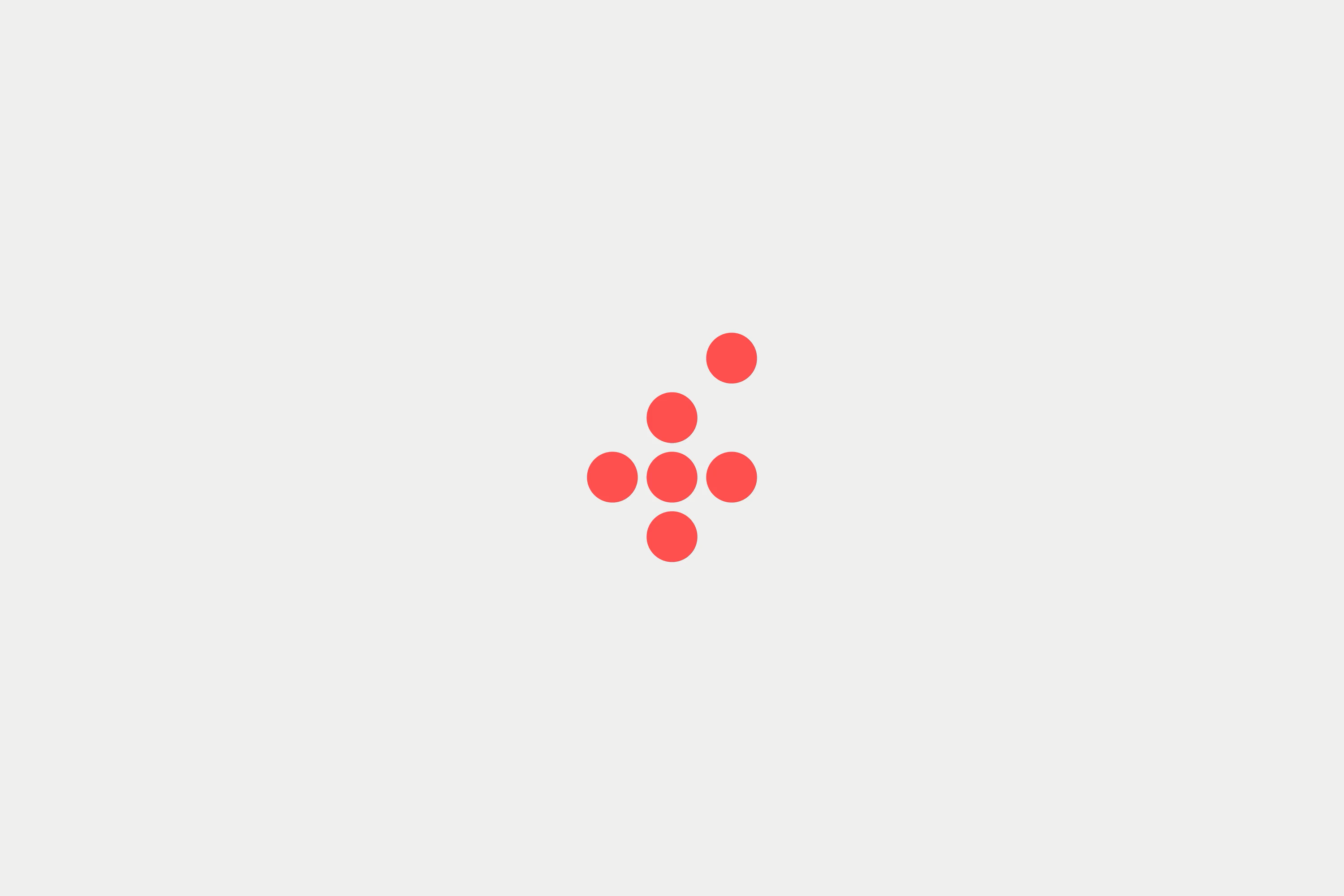 A minimalist geometric composition featuring a cross or plus-sign pattern made of seven red circles arranged symmetrically on a neutral beige background. The design exemplifies restraint and clarity through its use of negative space and simple circular forms.