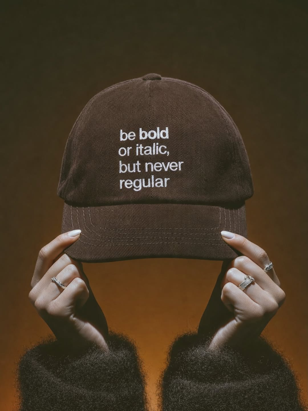 This is a highly stylized, moody photograph that focuses on the contrast between casual streetwear and intentional typographic design. The image uses earthy tones and sharp focus to create an editorial feel, emphasizing a subtle commentary on text usage.