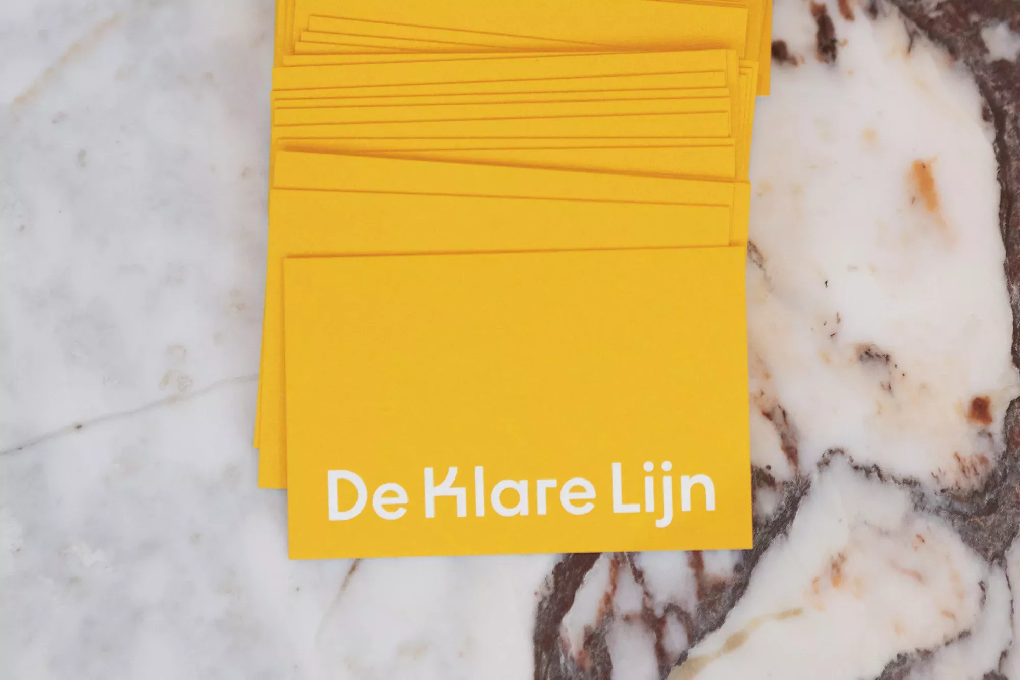 The image displays a stack of bright yellow cards, suggesting a clean, modern, and minimalist design aesthetic. The composition is simple, focusing entirely on the color and the text, conveying a sense of clarity and professionalism.