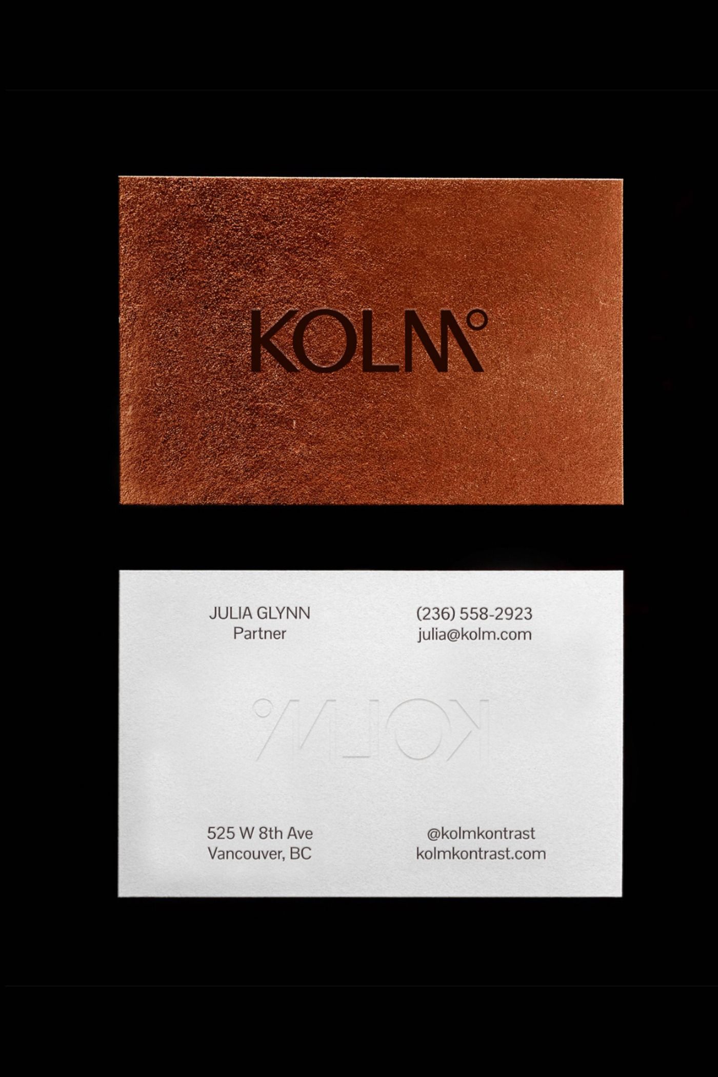 This design utilizes a sophisticated, minimalist approach, relying heavily on material texture and high contrast to convey a sense of refined luxury. The visual language is grounded and warm, pairing an earthy, textured surface with clean white typography for essential contact information.