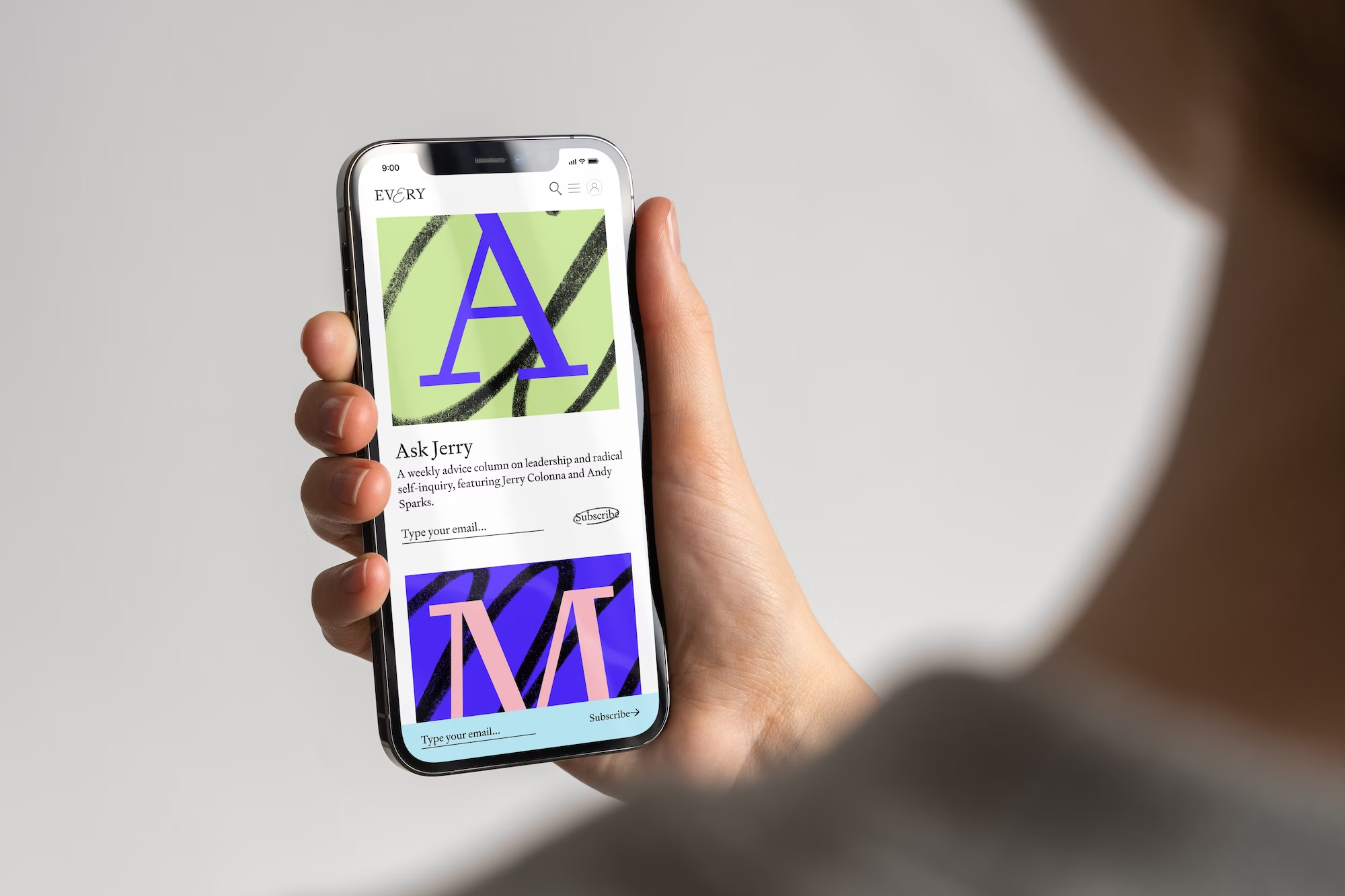 The image features a close-up of a hand holding a smartphone displaying a minimalist, modern interface. The design utilizes bold, geometric letterforms against a light background, suggesting a clean and professional digital experience.
