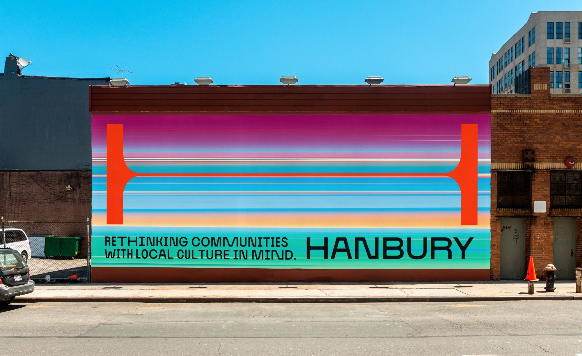 This is a vibrant, large-scale mural utilizing bold geometric shapes and layered horizontal bands to create an energetic urban aesthetic. The design employs high contrast and saturated colors to communicate a message about community culture in a dynamic visual language.