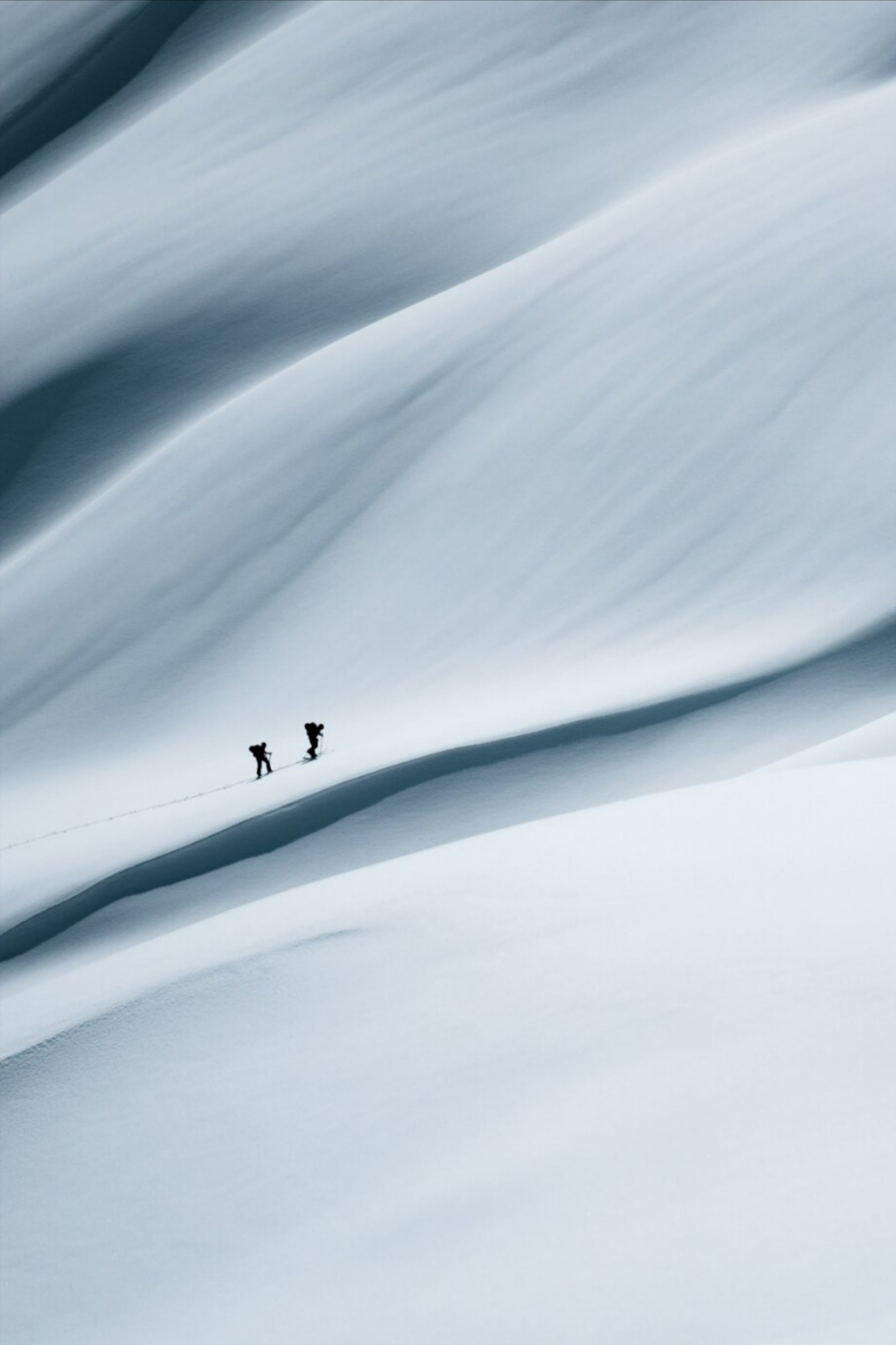 This image showcases a minimalist and serene landscape photograph characterized by smooth, sweeping diagonal lines that convey the vastness of the environment. The visual language relies on subtle tonal shifts and high atmospheric clarity to create an ethereal and quiet sense of movement.