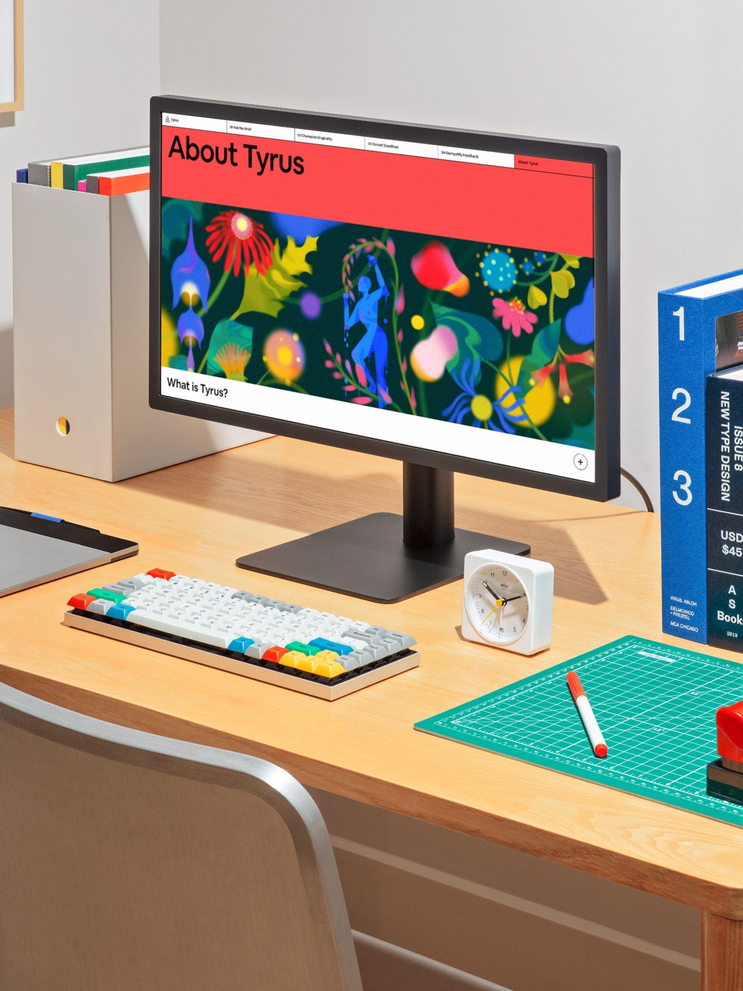 This image captures a modern, organized workspace blending digital creativity with physical tools. The composition highlights the vibrant, nature-inspired graphic on the monitor against a clean, warm wooden desk surface, emphasizing functionality and focused design work.