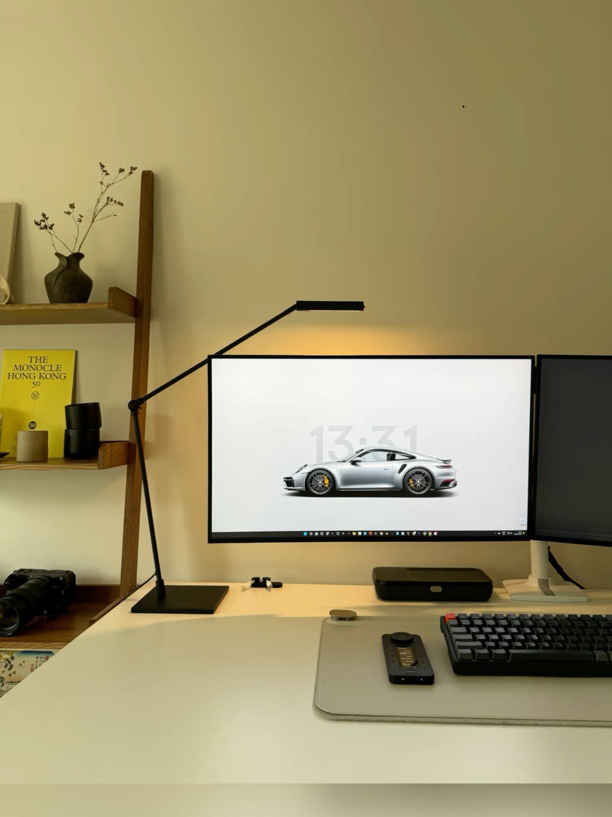 This image showcases a highly organized and minimalist workspace blending natural wood tones with sleek black technology. The visual language emphasizes clean lines, functional design, and a sophisticated, contemporary aesthetic suitable for professional or creative work.