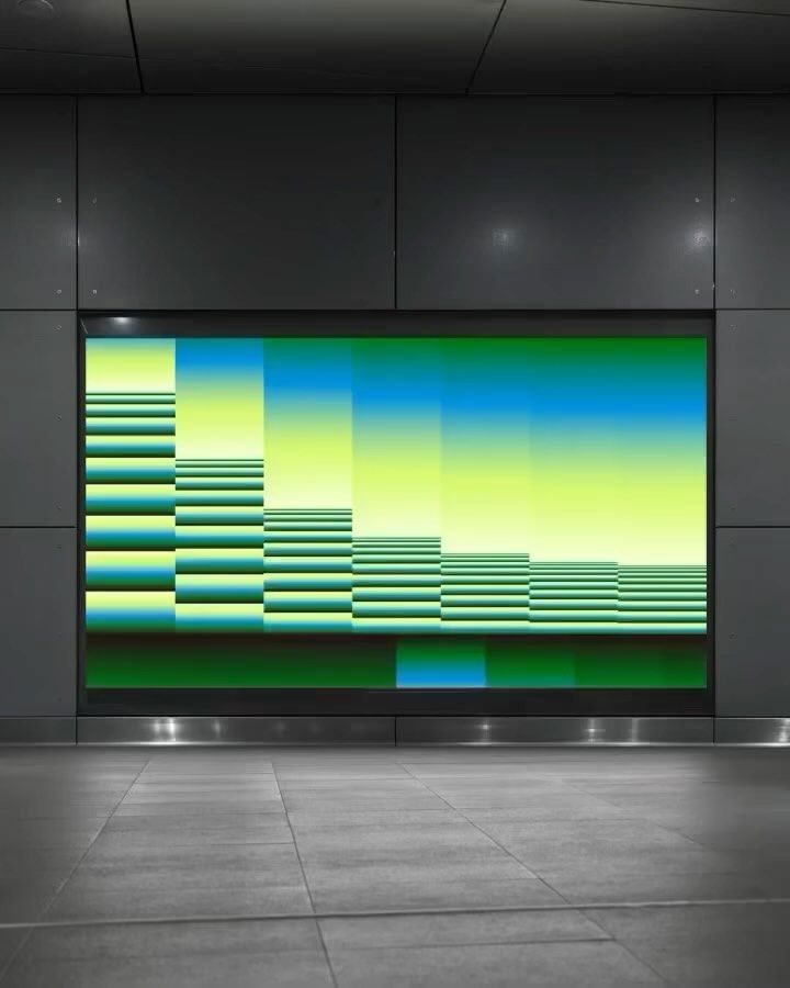 The image presents a modern, minimalist display featuring a vibrant, abstract bar chart visualization against a dark, subdued background. The design emphasizes clean lines, strong color blocking, and a sense of data presentation within a sleek, institutional setting.