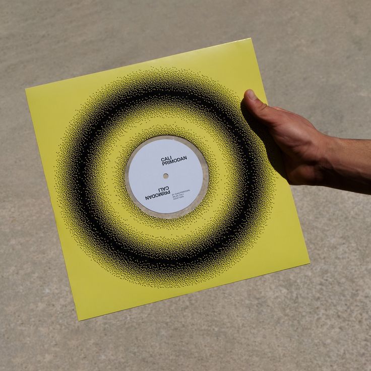 This image features a minimalist, high-contrast design centered around a circular graphic element on a bright yellow background. The visual language relies heavily on texture created by dense black speckling radiating outward, suggesting depth or energy.