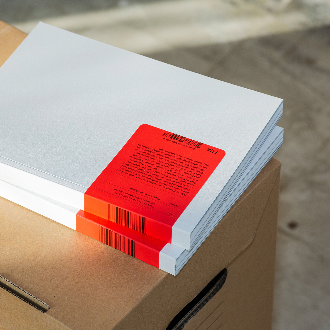 The image features a clean, minimalist presentation of printed materials, emphasizing stark contrast between white paper and a vibrant red accent. The design relies on precise alignment and the tactile quality of the paper stock to convey a sense of professional, modern information delivery.