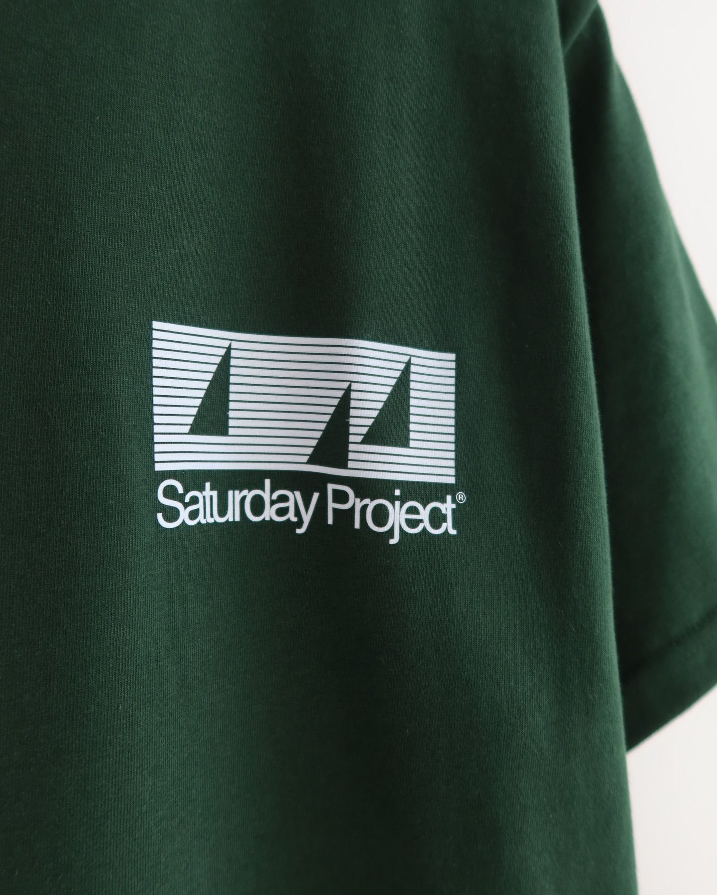 This image showcases minimalist graphic design applied to a dark textile, featuring clean lines and simple typography for branding. The visual language emphasizes clarity, structure, and a muted color palette suitable for modern streetwear or casual apparel.