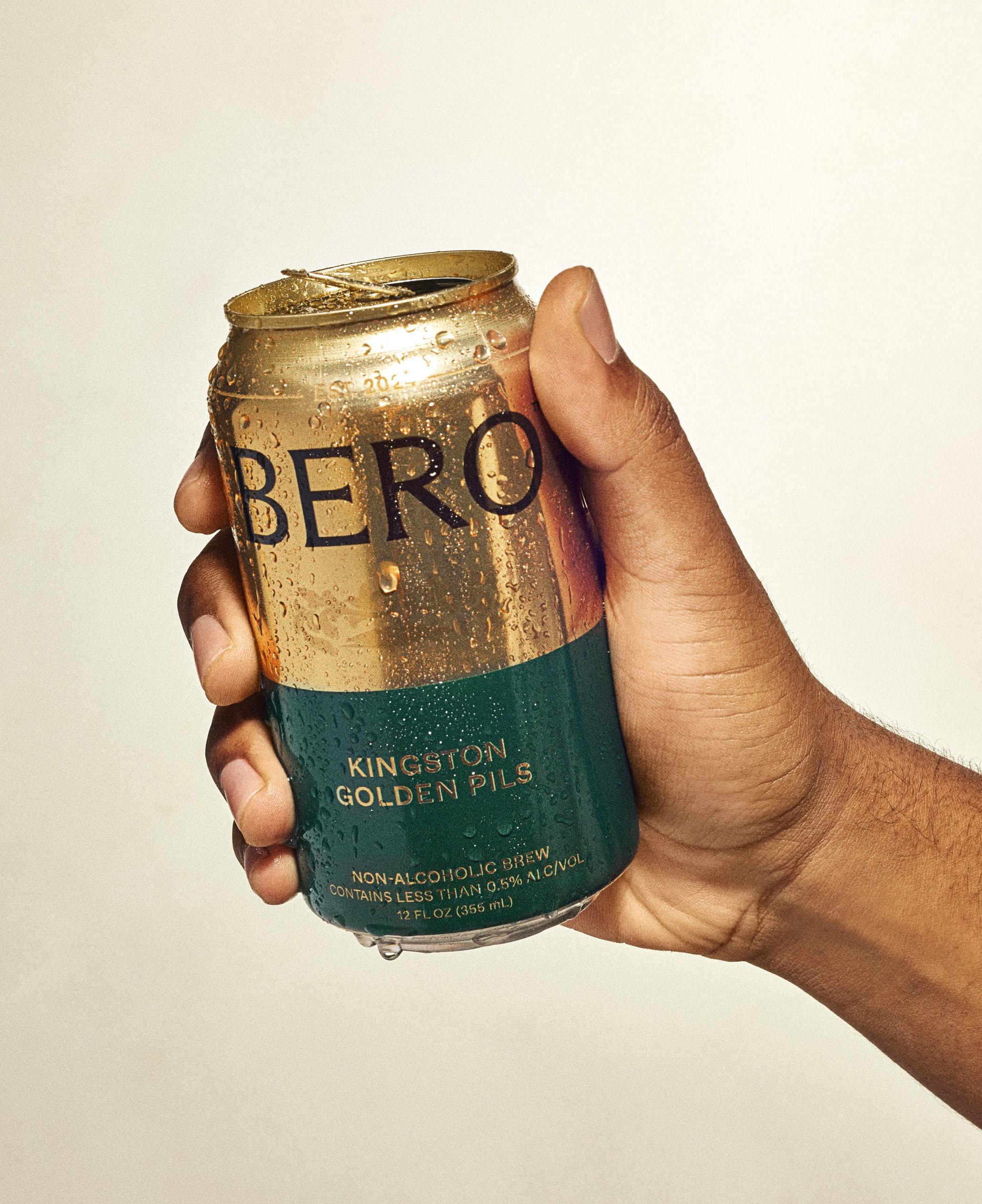 This image utilizes soft, natural lighting to showcase a beverage can, emphasizing the rugged texture and vintage aesthetic of the branding. The visual language is grounded in earthy tones and industrial presentation, creating a sense of artisanal quality and authenticity.