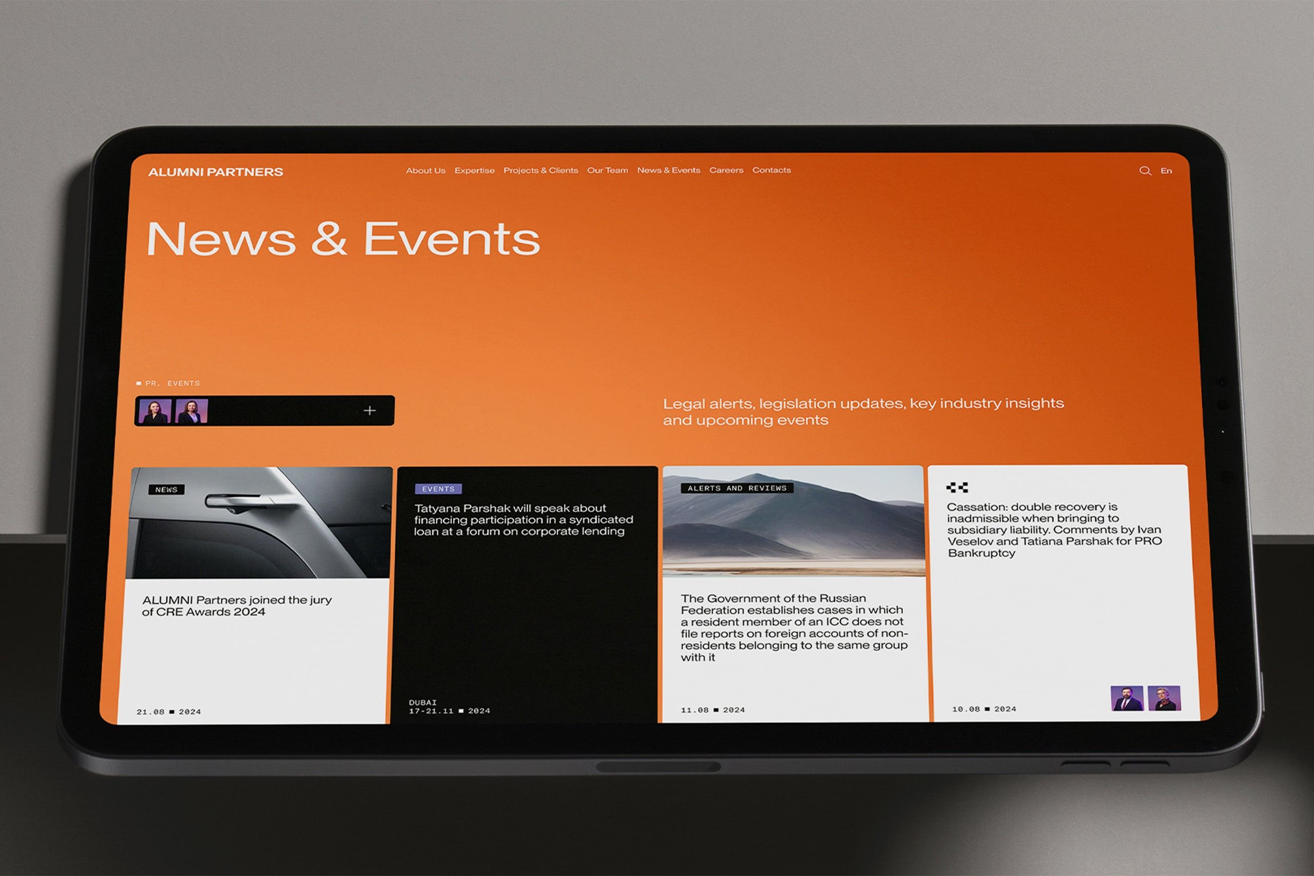 The design employs a professional and high-contrast aesthetic, utilizing a warm orange background against a dark field to create a sophisticated yet inviting feel. The layout is clean and organized, emphasizing readability and clear delineation of news items and events.