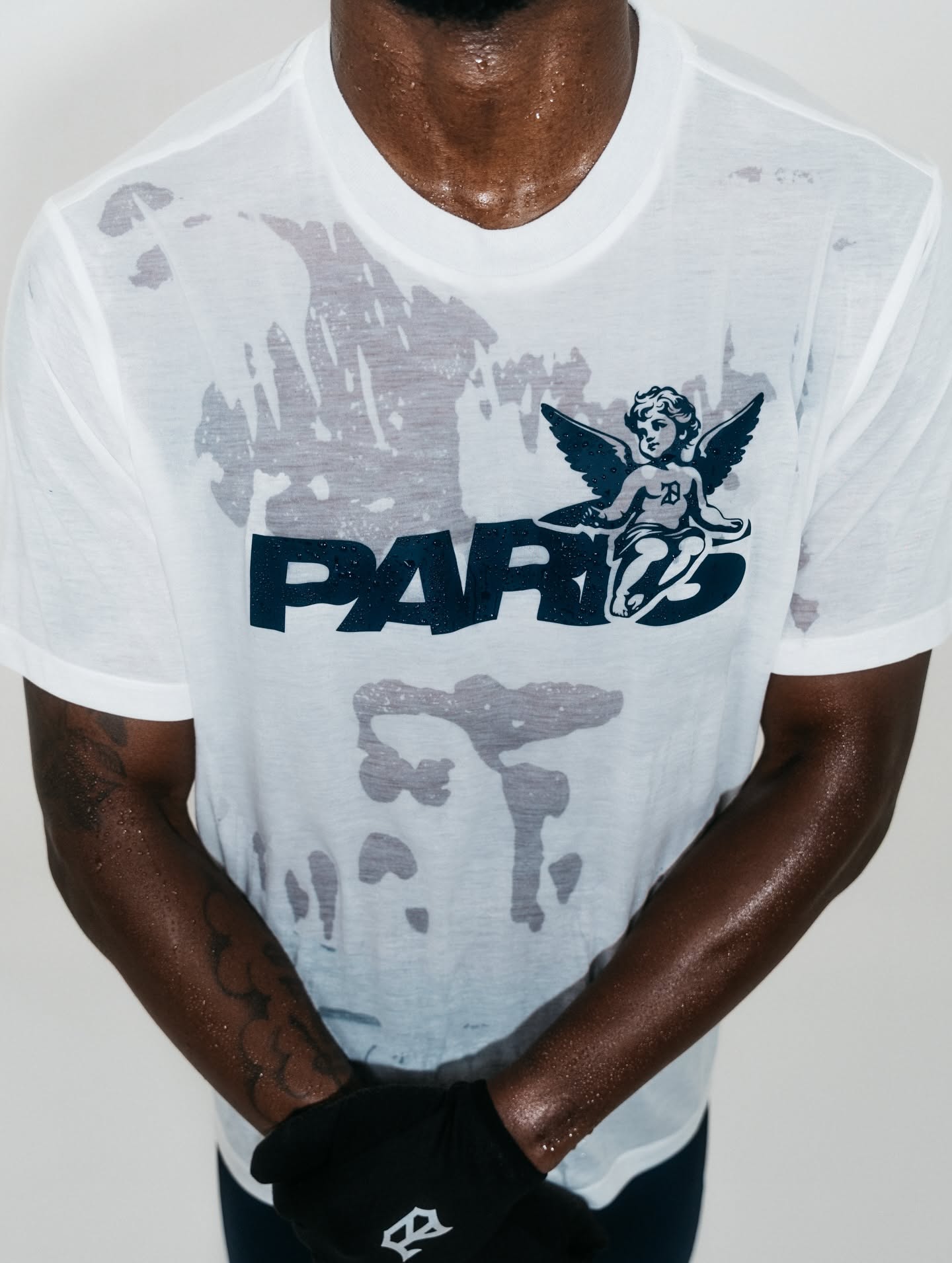 This image showcases a piece of graphic streetwear featuring distressed textures and bold illustrative elements. The design blends vintage aesthetics with modern urban sensibilities through high-contrast grayscale printing on a stark white fabric.