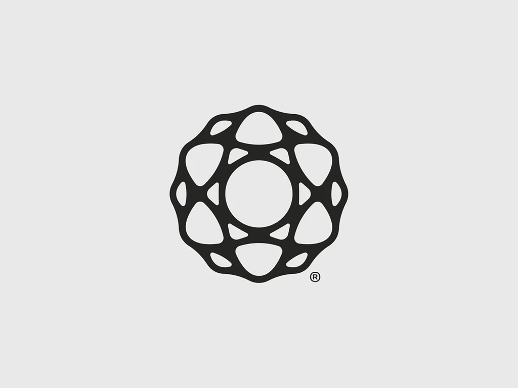 This design features an intricate, symmetrical geometric pattern rendered in solid black line work against a neutral gray background. The visual language balances organic curves with precise, repeating polygonal shapes, creating a sense of structured elegance and complexity.